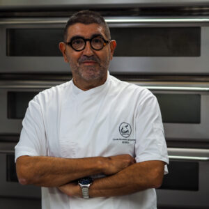 Foto de Pedro García Espasandín, con los brazos cruzados sobre la chaqueta de la «Escola Obradoiro de Pastelería Gascón, Ferrol»